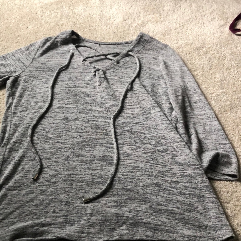 A grey see through shirt wit strings in the front
